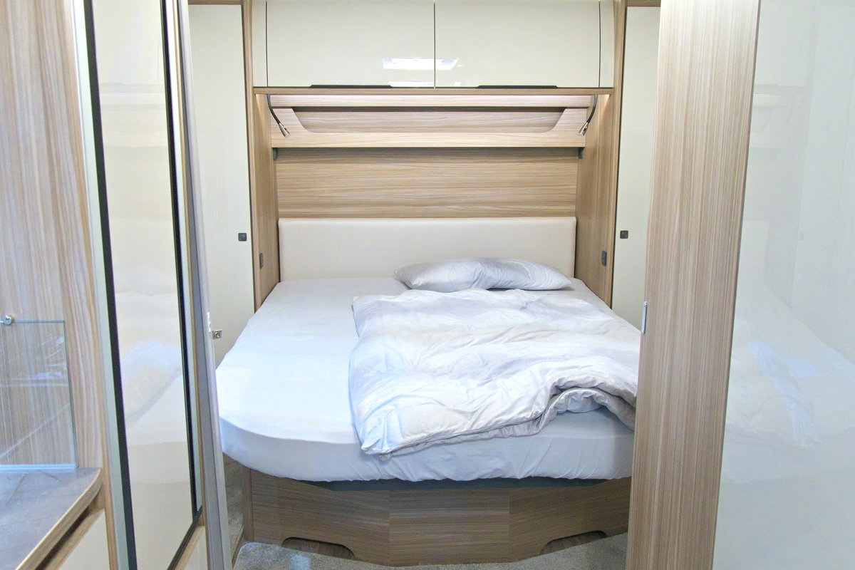 Fendt Tendenza 560 SFDW auf dem Caravan Salon 2026: Französisches Längsbett im Heck mit Oberschränken.