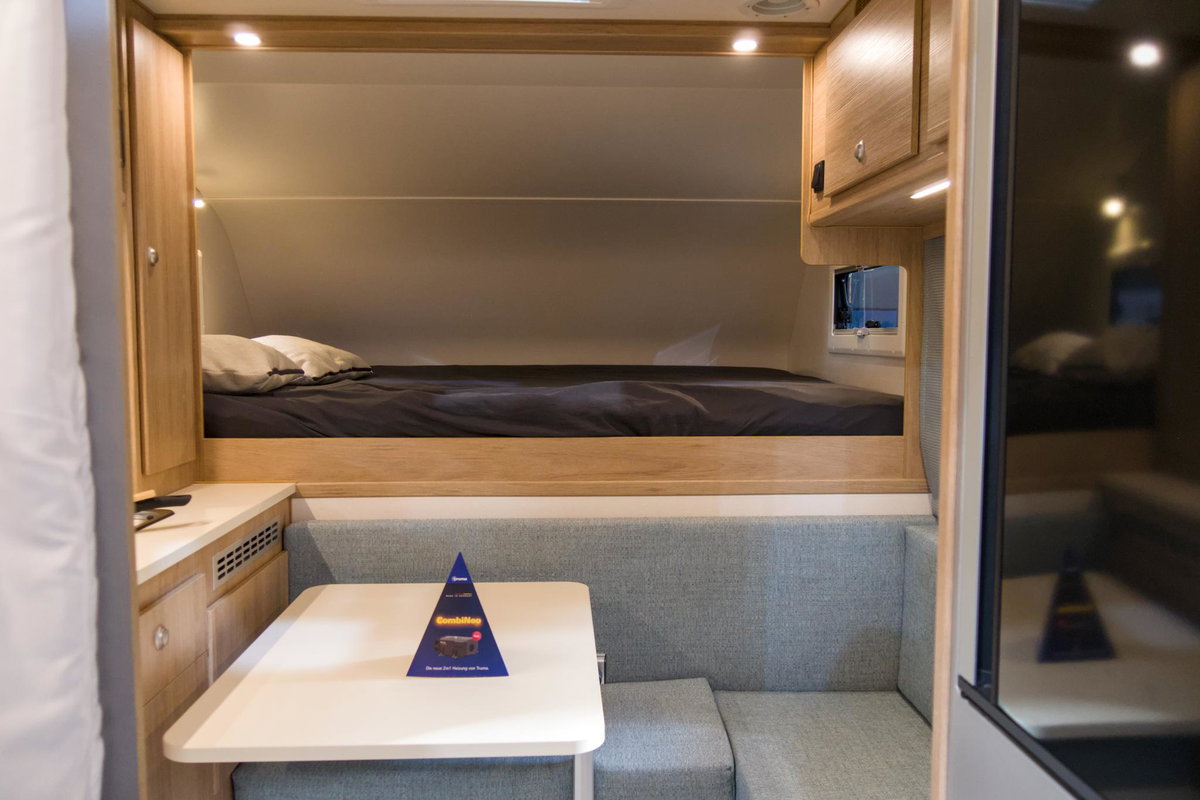 Tischer 200 Superlight auf dem Caravan Salon 2026: Blick auf das Bett und die Sitzgruppe.